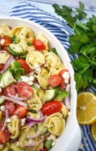 Mediterranean tortellini pasta salad on a white serving bowl