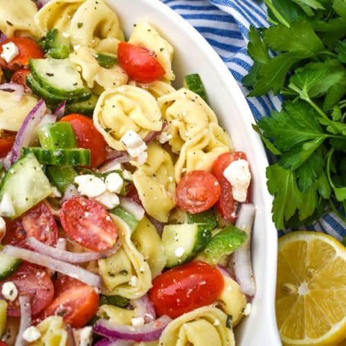 Mediterranean tortellini pasta salad on a white serving bowl