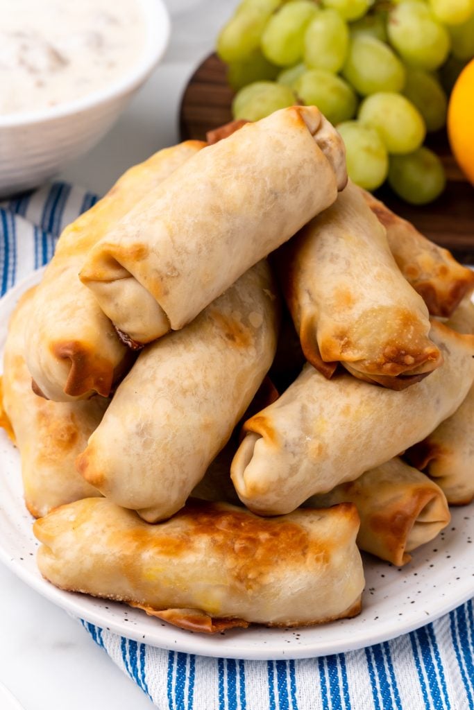 a pile of baked breakfast egg rolls on a white plate