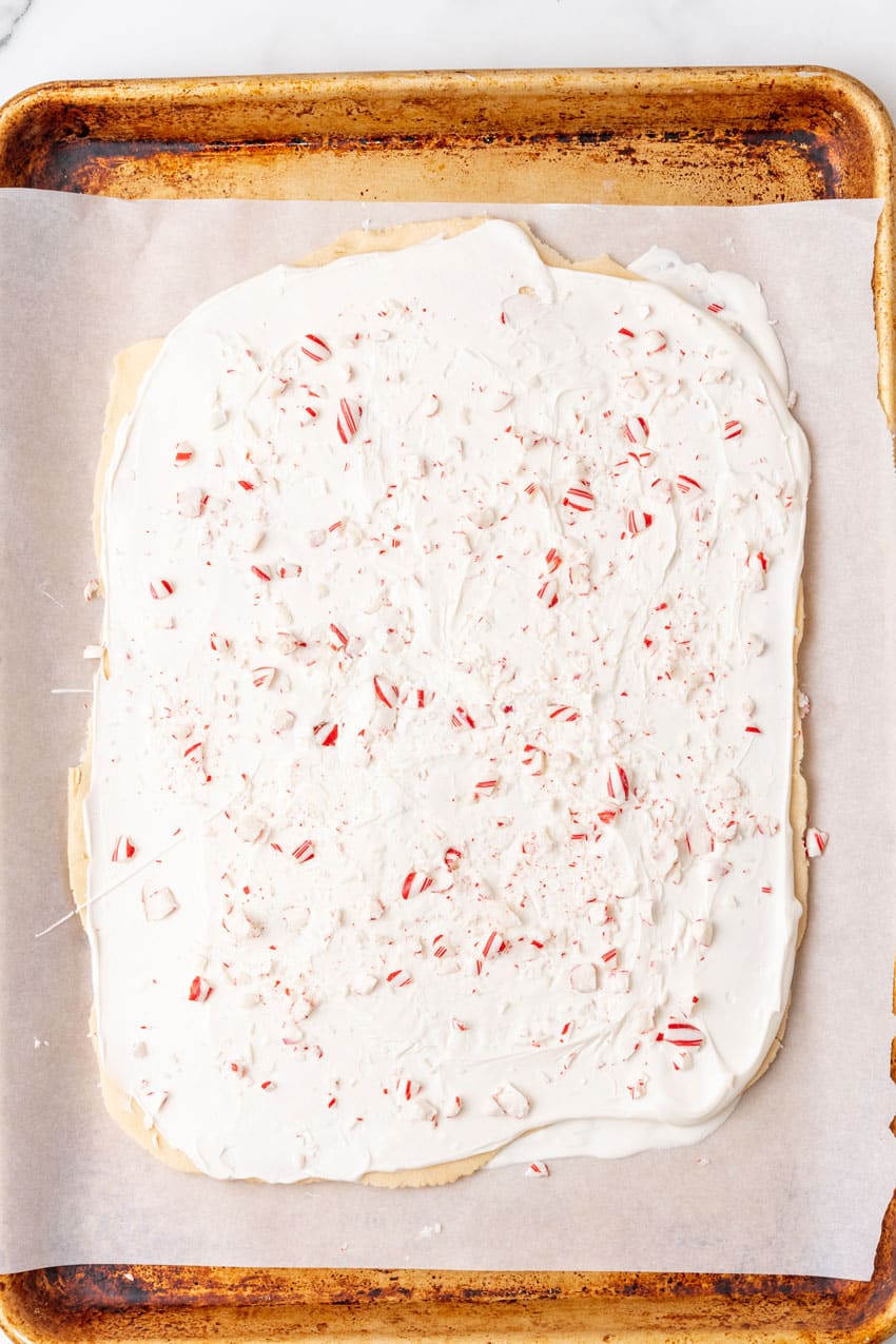 peppermint sugar cookie bark on a white parchment paper lined baking sheet