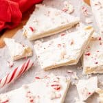 peppermint sugar cookie bark pieces on a parchment paper covered wooden cutting board