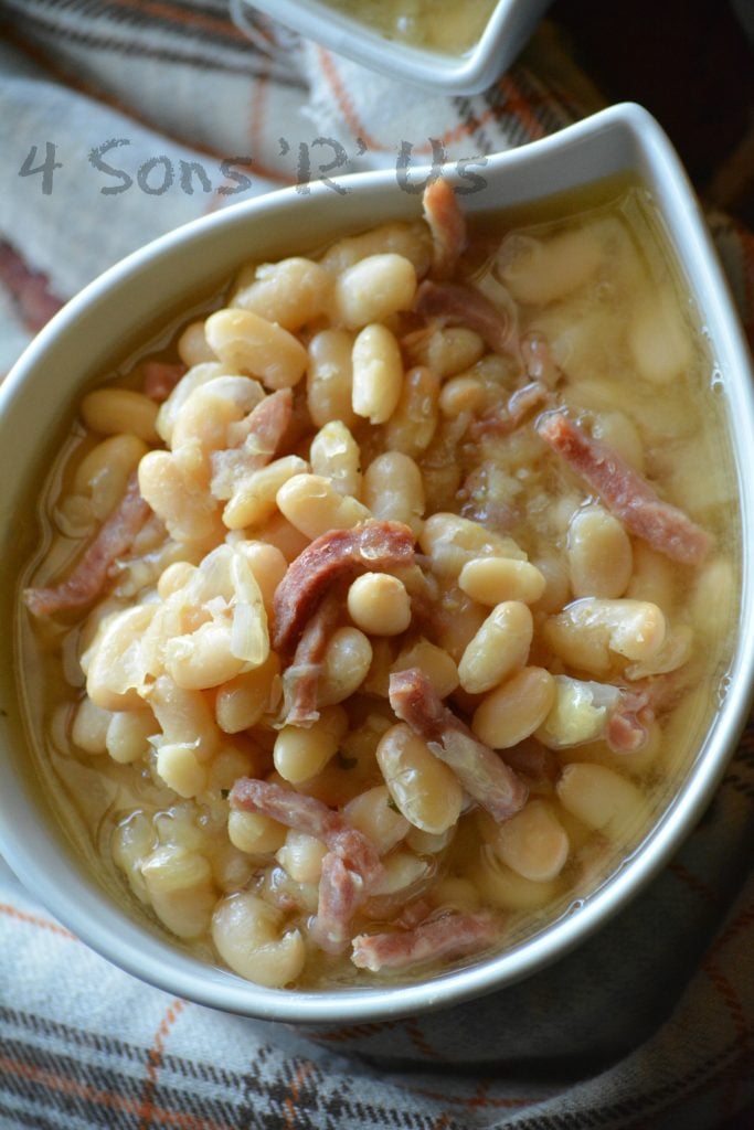 Crockpot ham & white bean soup shown served in white bowls on a flannel napkin