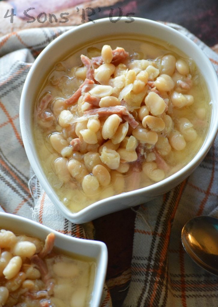 Crockpot ham & white bean soup shown served in white bowls on a flannel napkin