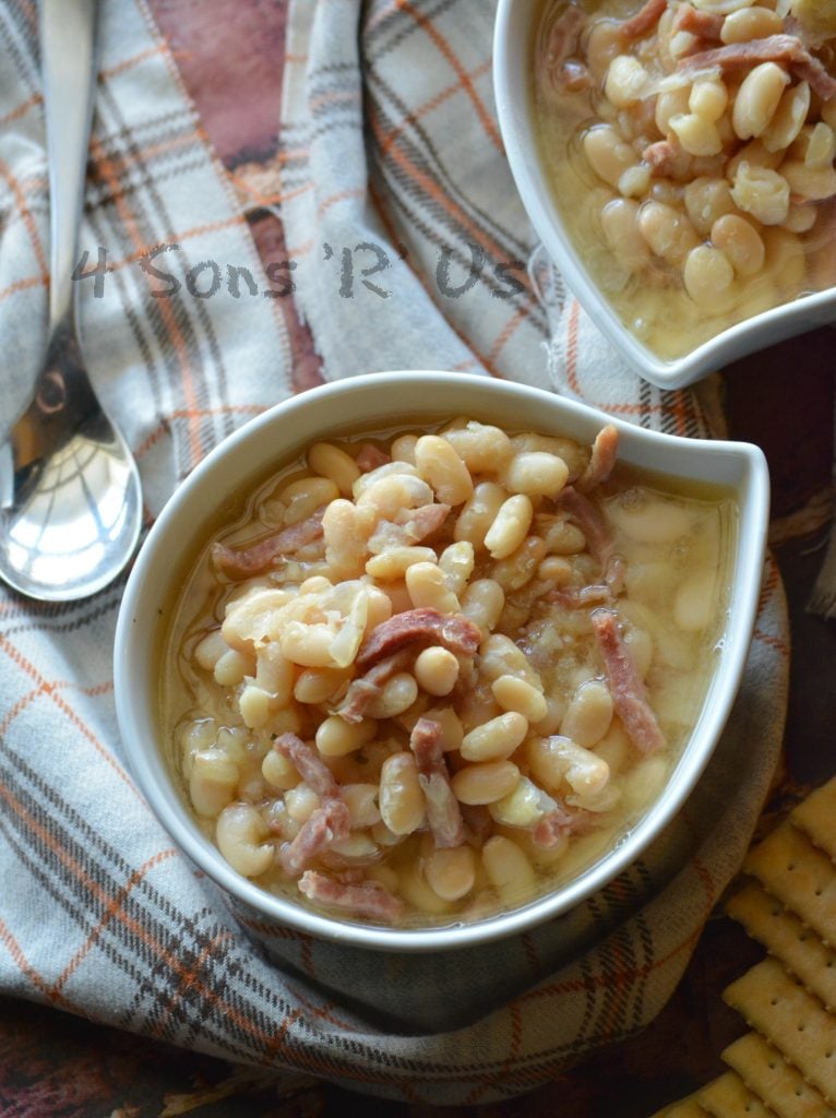 Crockpot ham & white bean soup shown served in white bowls on a flannel napkin