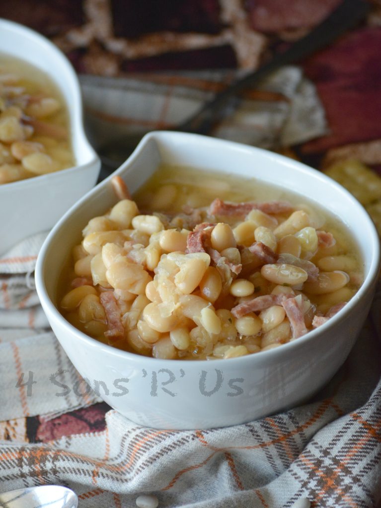 Crockpot ham & white bean soup shown served in white bowls on a flannel napkin