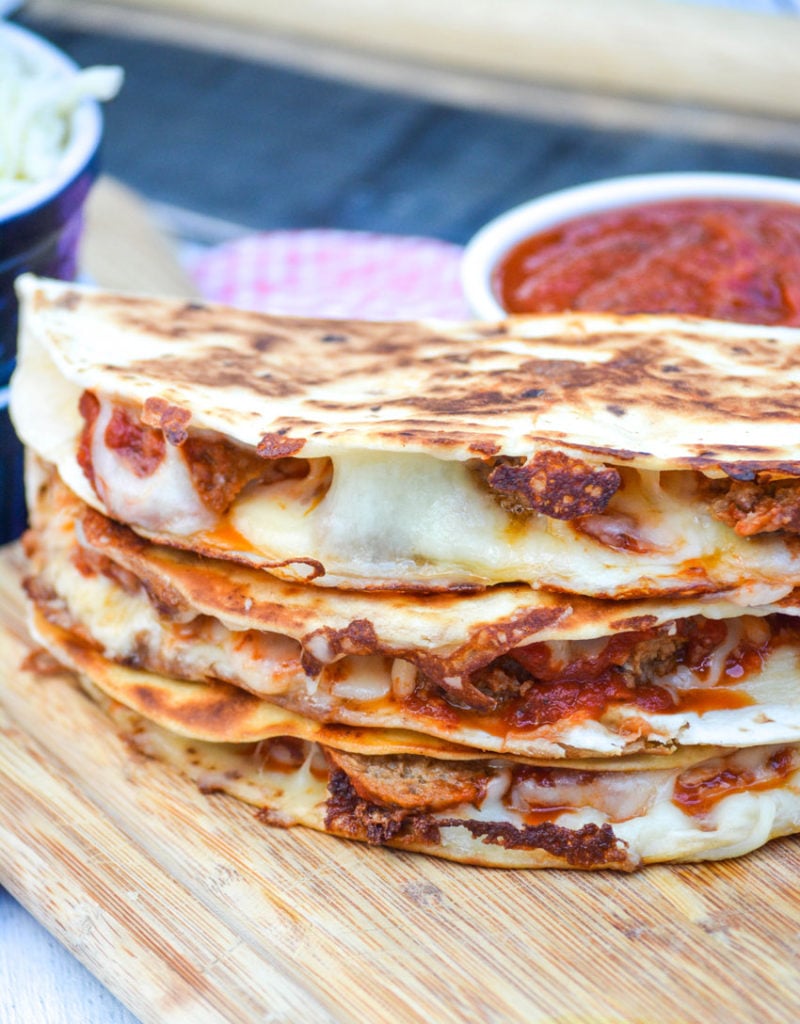 a stack of meatball quesadillas on a wooden cutting board