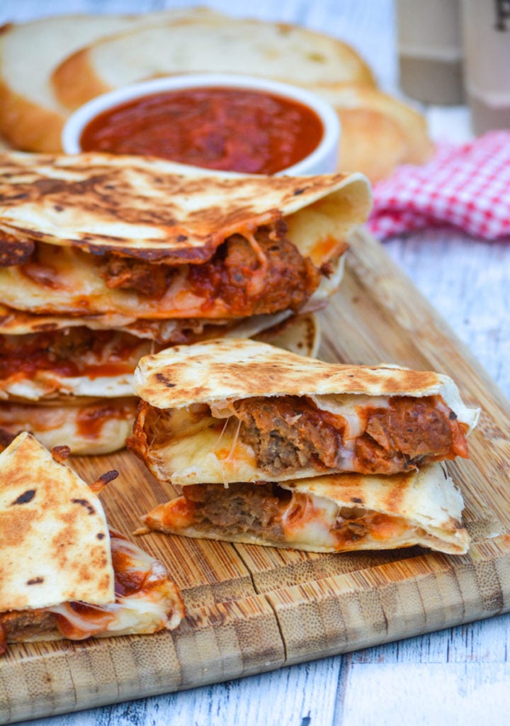 sliced meatball quesadillas on a wooden cutting board