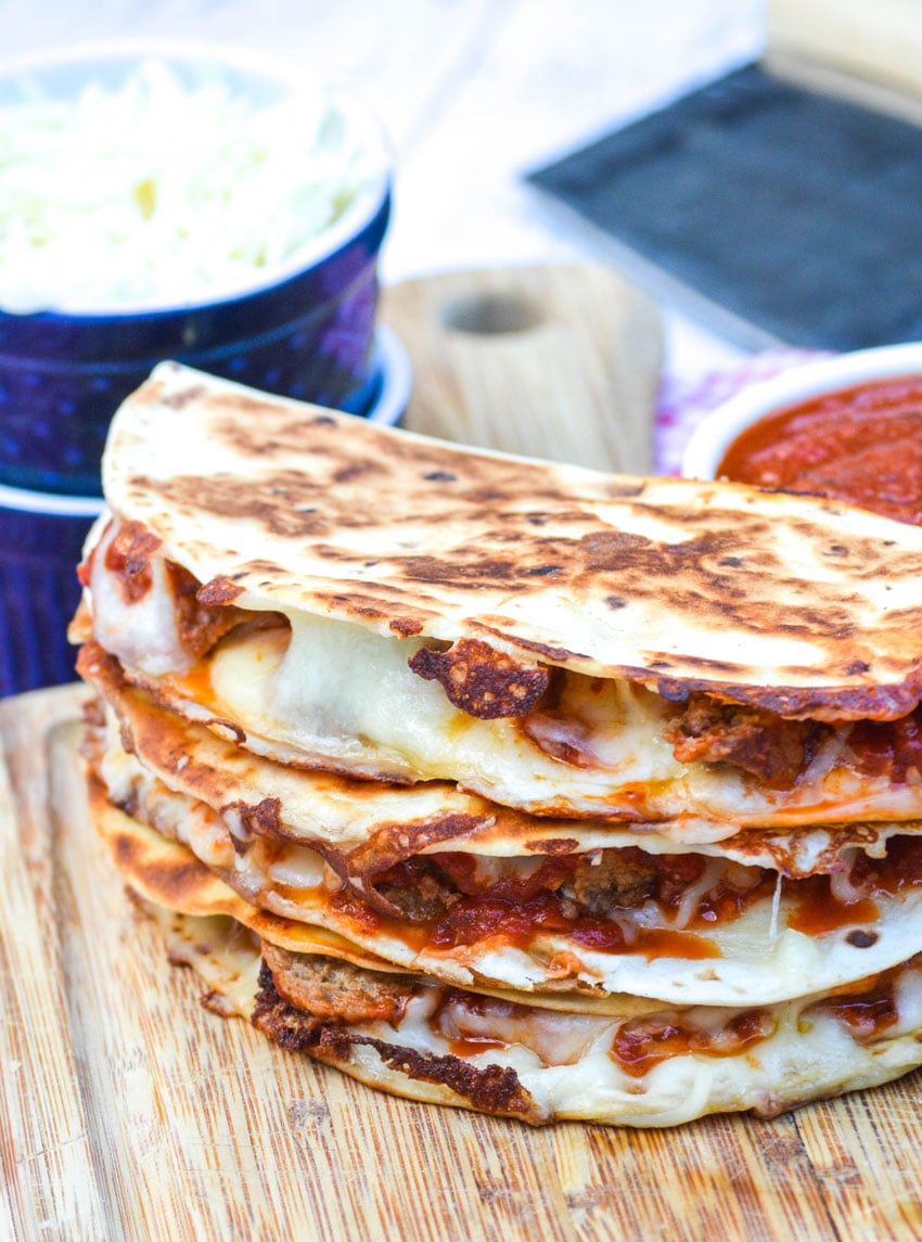 a stack of meatball quesadillas on a wooden cutting board