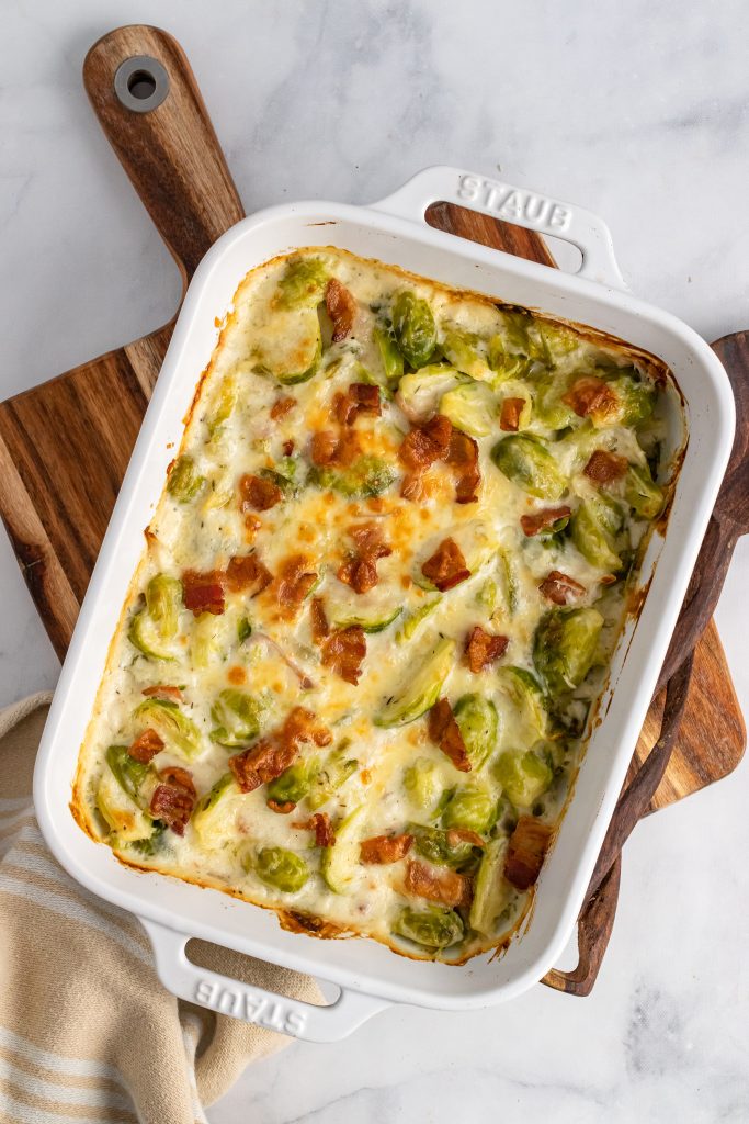 brussels sprouts gratin casserole in a white casserole dish