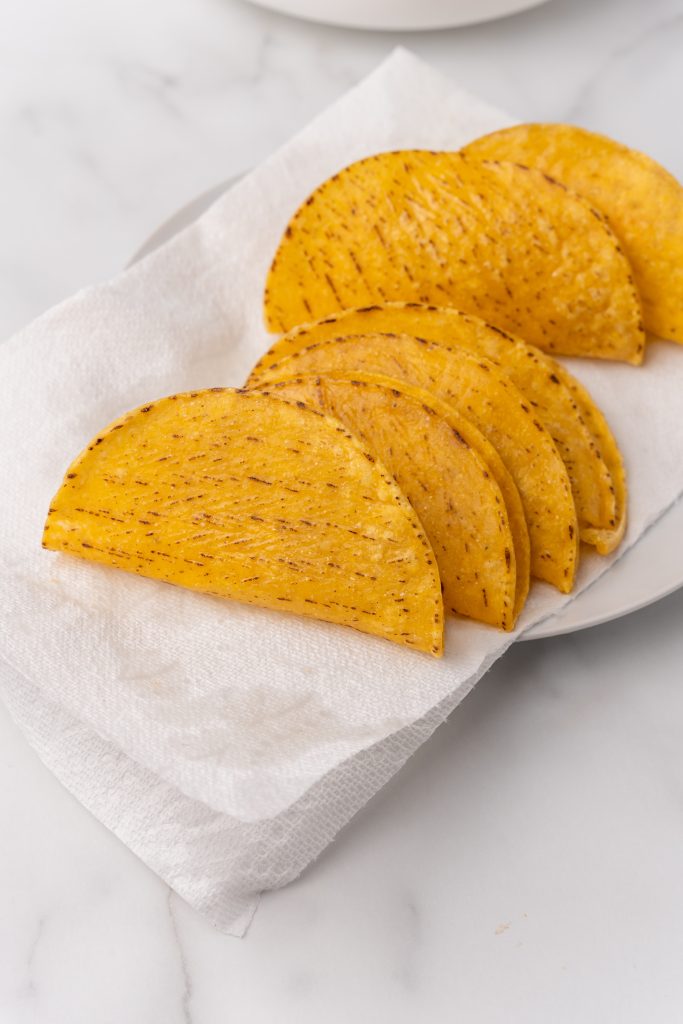 fried corn tortilla shells on a paper towel lined plate