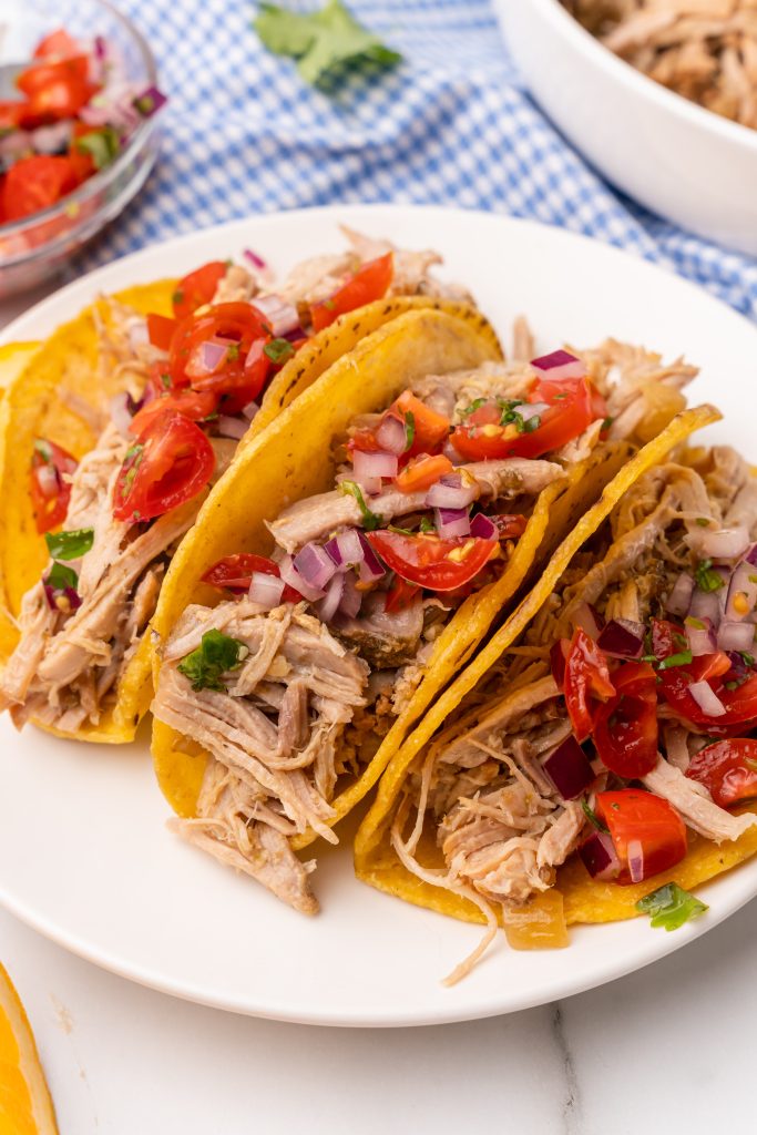slow cooker pulled pork carnitas arranged on a white serving plate