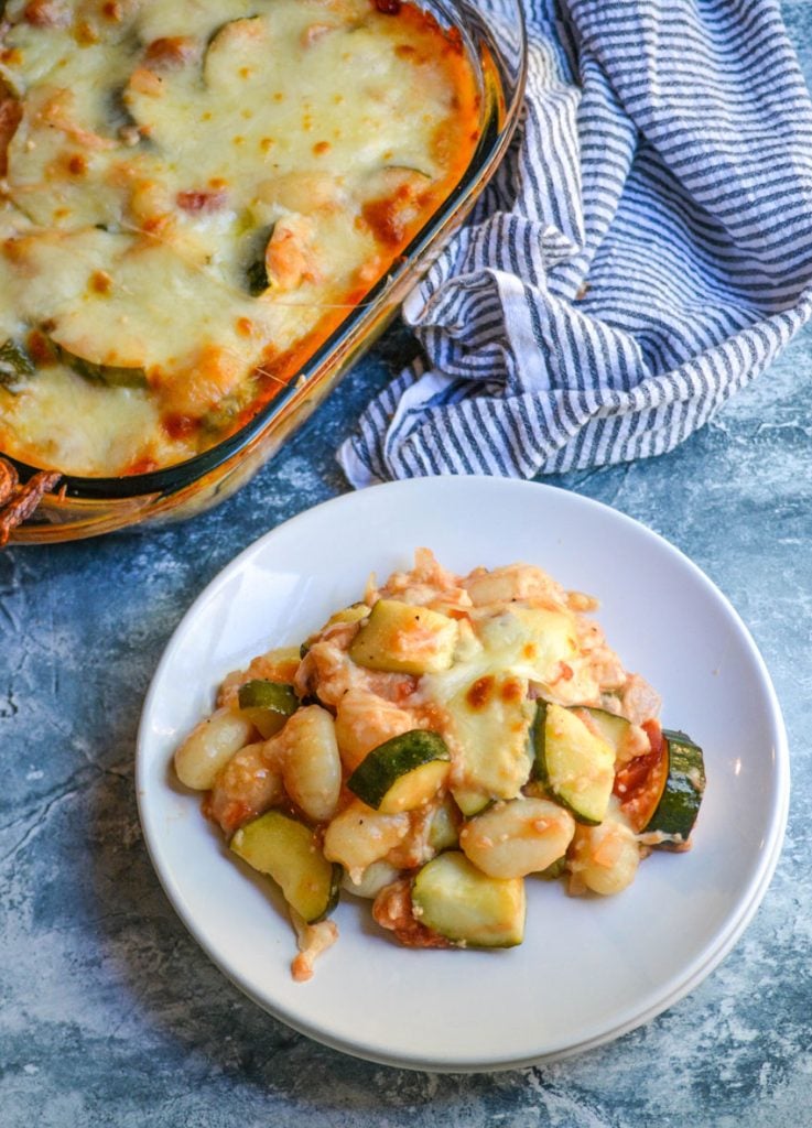 baked gnocchi with zucchini & tomatoes served on a white plate