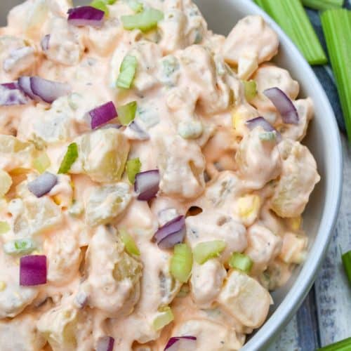 buffalo potato salad in a shallow serving bowl with celery sticks on the side