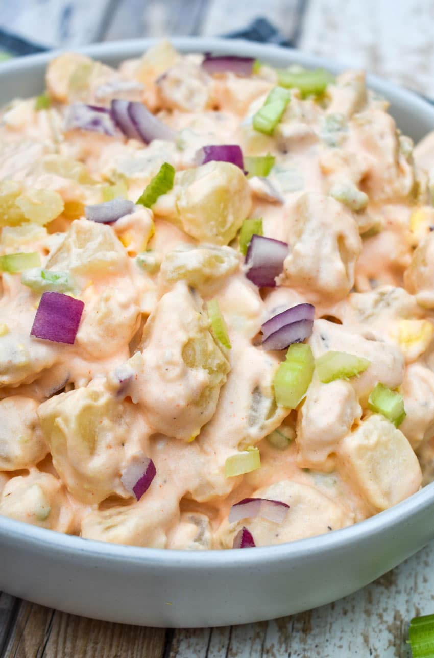 buffalo potato salad in a shallow serving bowl with celery sticks on the side