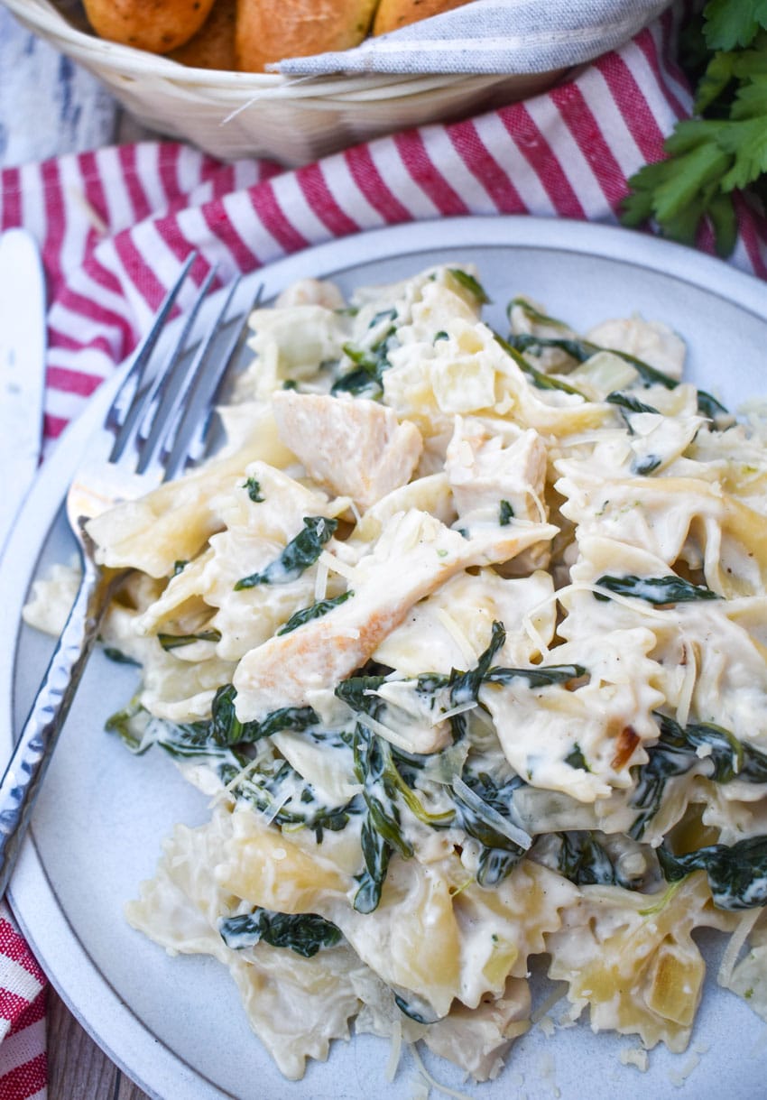 chicken florentine and farfalle paste on a white plate