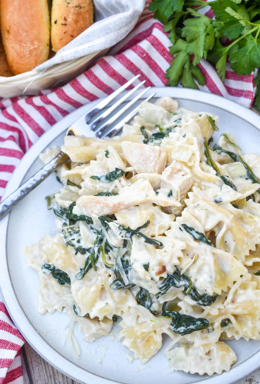 chicken florentine and farfalle paste on a white plate