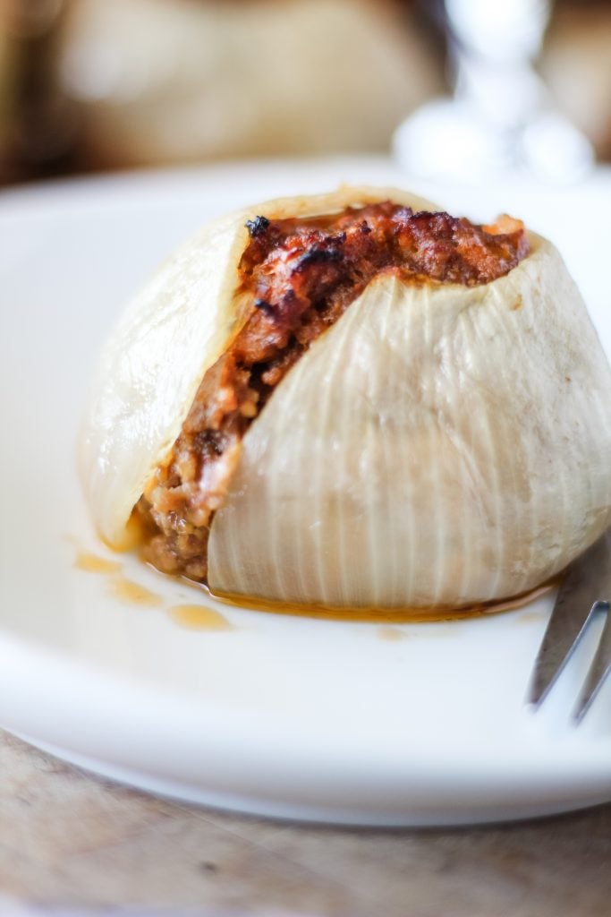 a grilled onion bomb served on a white plate