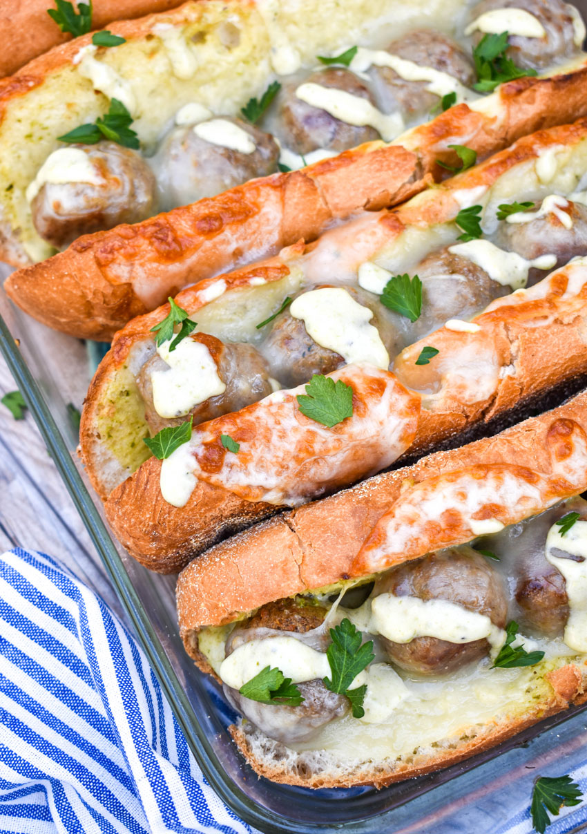 easy cheesy meatball subs with alfredo sauce in a glass baking dish
