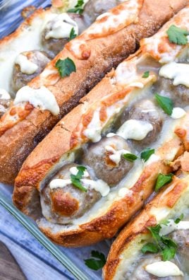 alfredo meatball subs with pesto in a glass baking dish