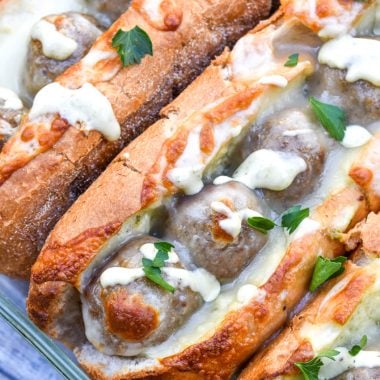 alfredo meatball subs with pesto in a glass baking dish