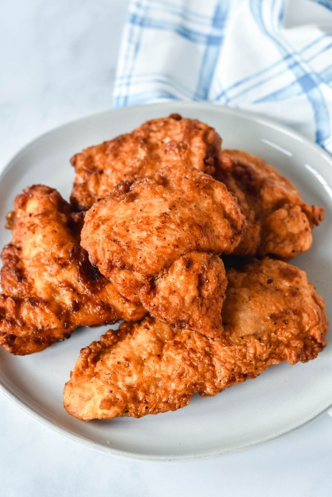 copycat chick fil a chicken on a white plate with a dishtowel in the background