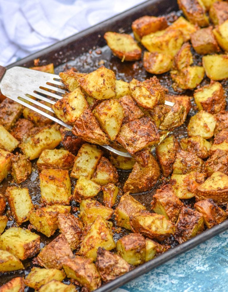 oven roasted pesto potatoes on spatula above a large baking sheet