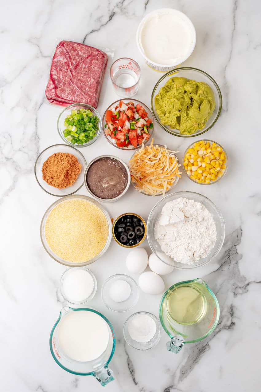 an overhead image showing the measured ingredients needed to make a 7 layer sheet pan cornbread casserole