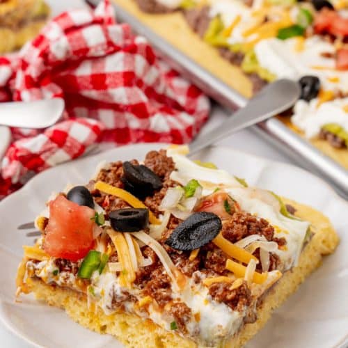 a slice of 7 later sheet pan cornbread casserole on a white plate