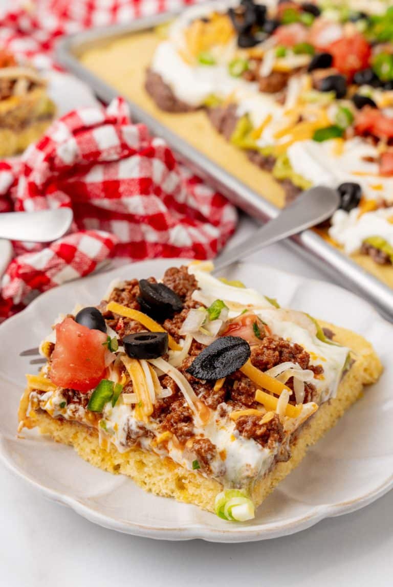 a slice of 7 later sheet pan cornbread casserole on a white plate