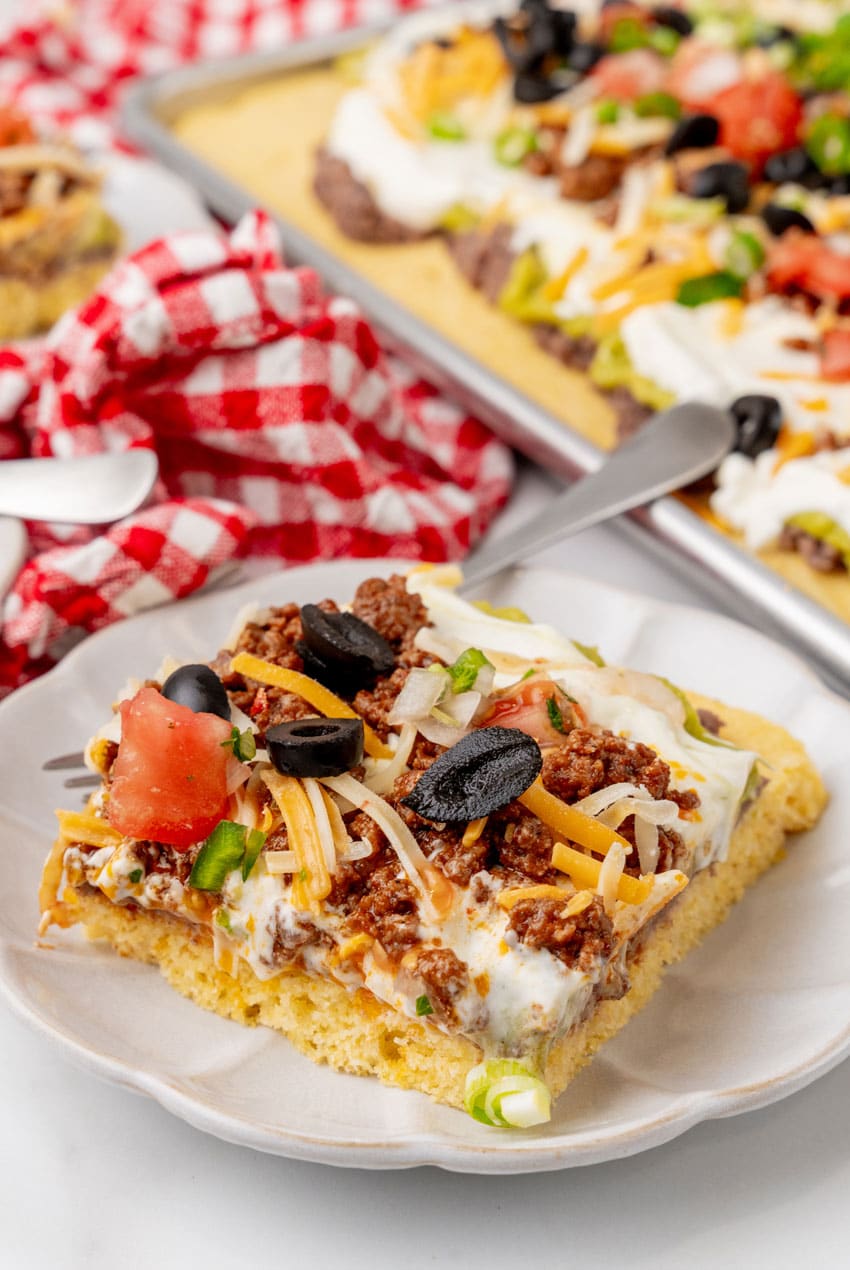 a slice of 7 later sheet pan cornbread casserole on a white plate