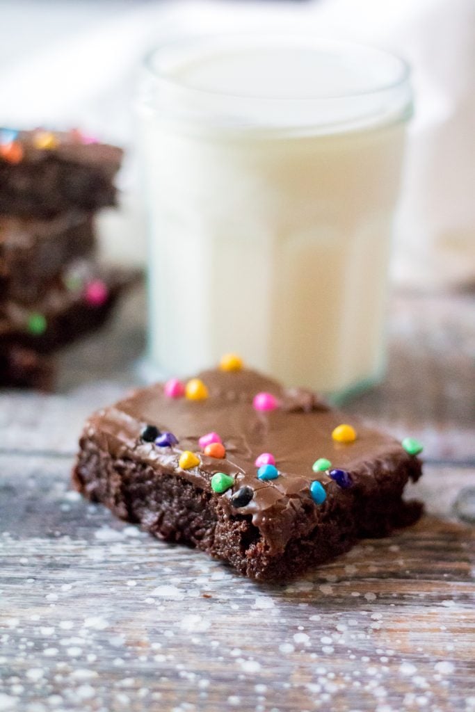 Cosmic brownie on a weathered wooden back drop with a glass of cold milk