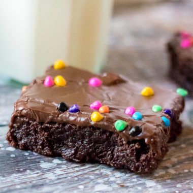 Cosmic brownie on a weathered wooden back drop with a glass of cold milk