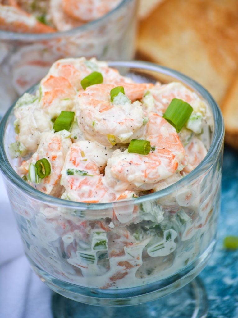 creamy shrimp salad topped with thinly sliced scallions and shown in a glass bowl