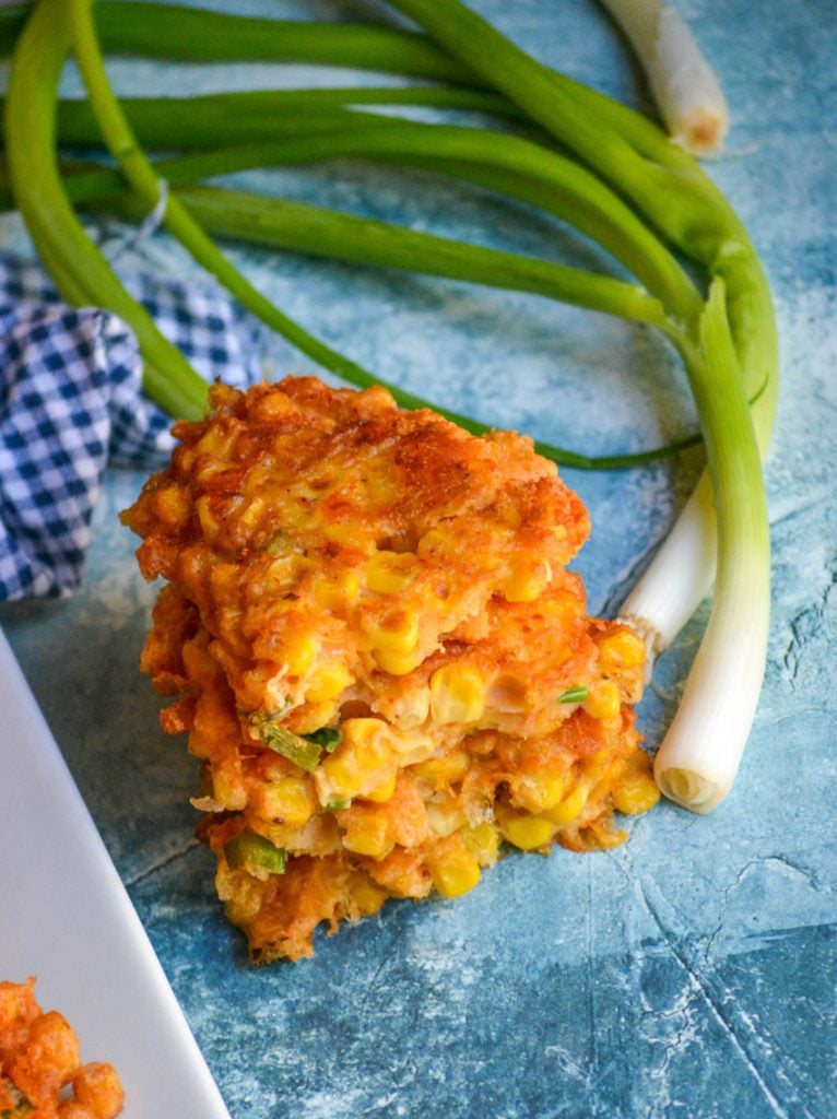 a stack of opened corn and cheddar cheese fritters showing the inside