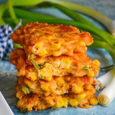 a stack of opened corn and cheddar cheese fritters showing the inside