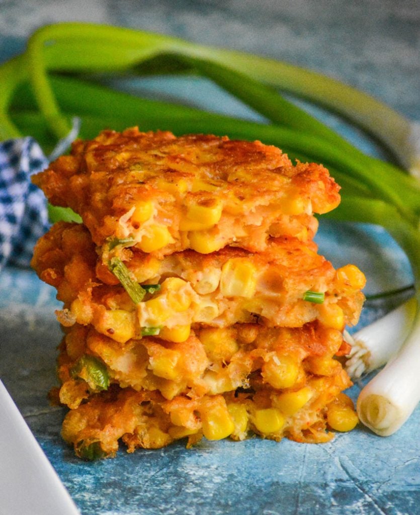 a stack of opened corn and cheddar cheese fritters showing the inside