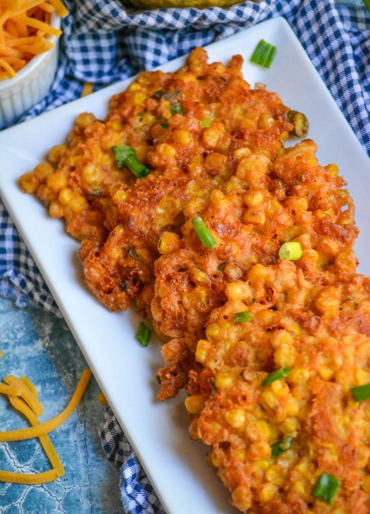 sweet corn cheddar cheese fritters served stacked on an white appetizer tray