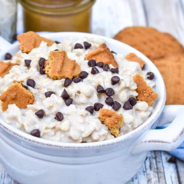 peanut butter cookie overnight oats in a bowl topped with crumbled cookies and miniature chocolate chips