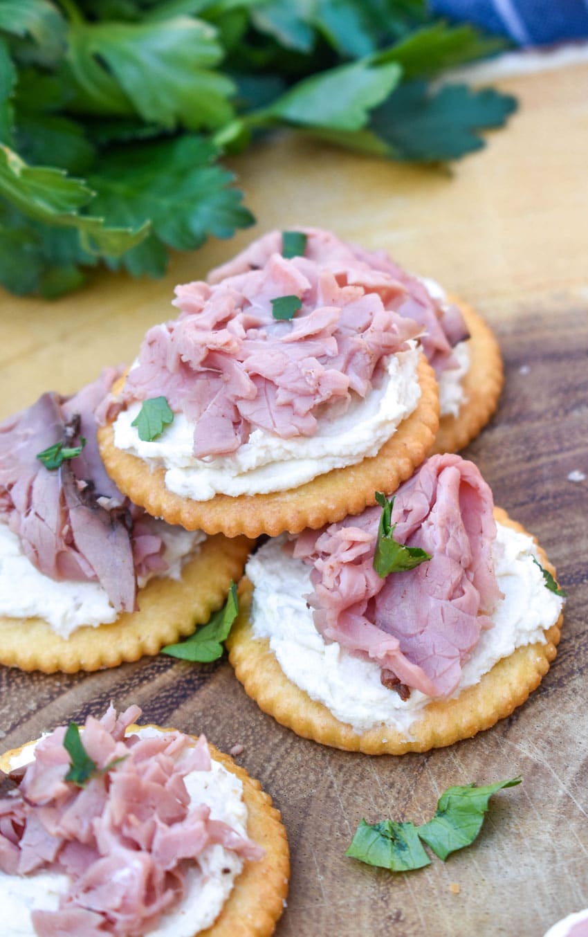 roast beef and horseradish cream cheese crackers on a wooden cutting board