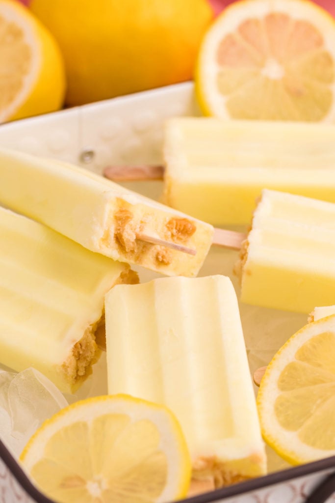 lemon pie pops shown over a bed of ice cubes and lemon slices