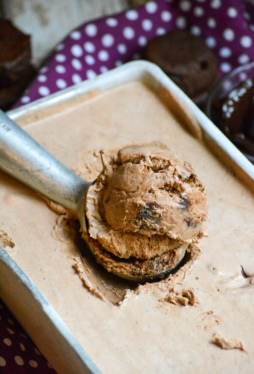 a silver ice cream scoop in a loaf pan filled with no churn fudge brownie ice cream