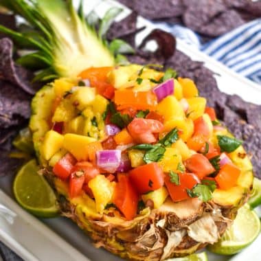 pineapple mango salsa in a hollowed out fresh pineapple on a white serving platter