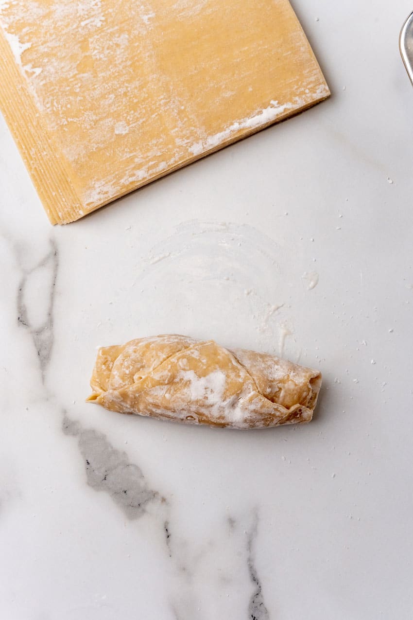 a rolled up homemade egg roll on a marble counter top