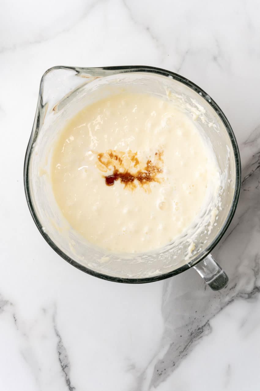 cheesecake batter with vanilla extract in a glass mixing bowl