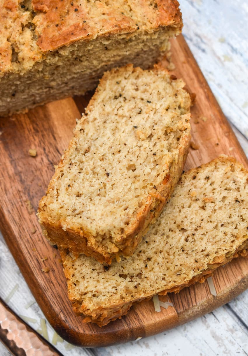 slices of black pepper parmesan beer bread on a wooden cutting board