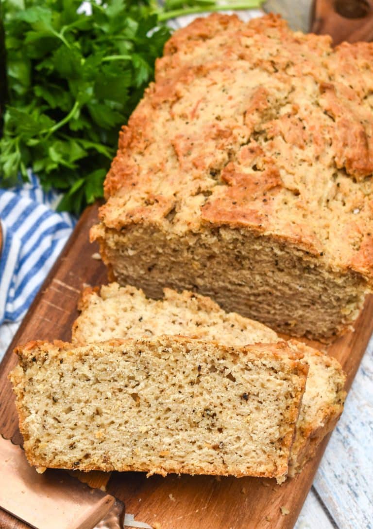 slices of black pepper parmesan beer bread on a wooden cutting board