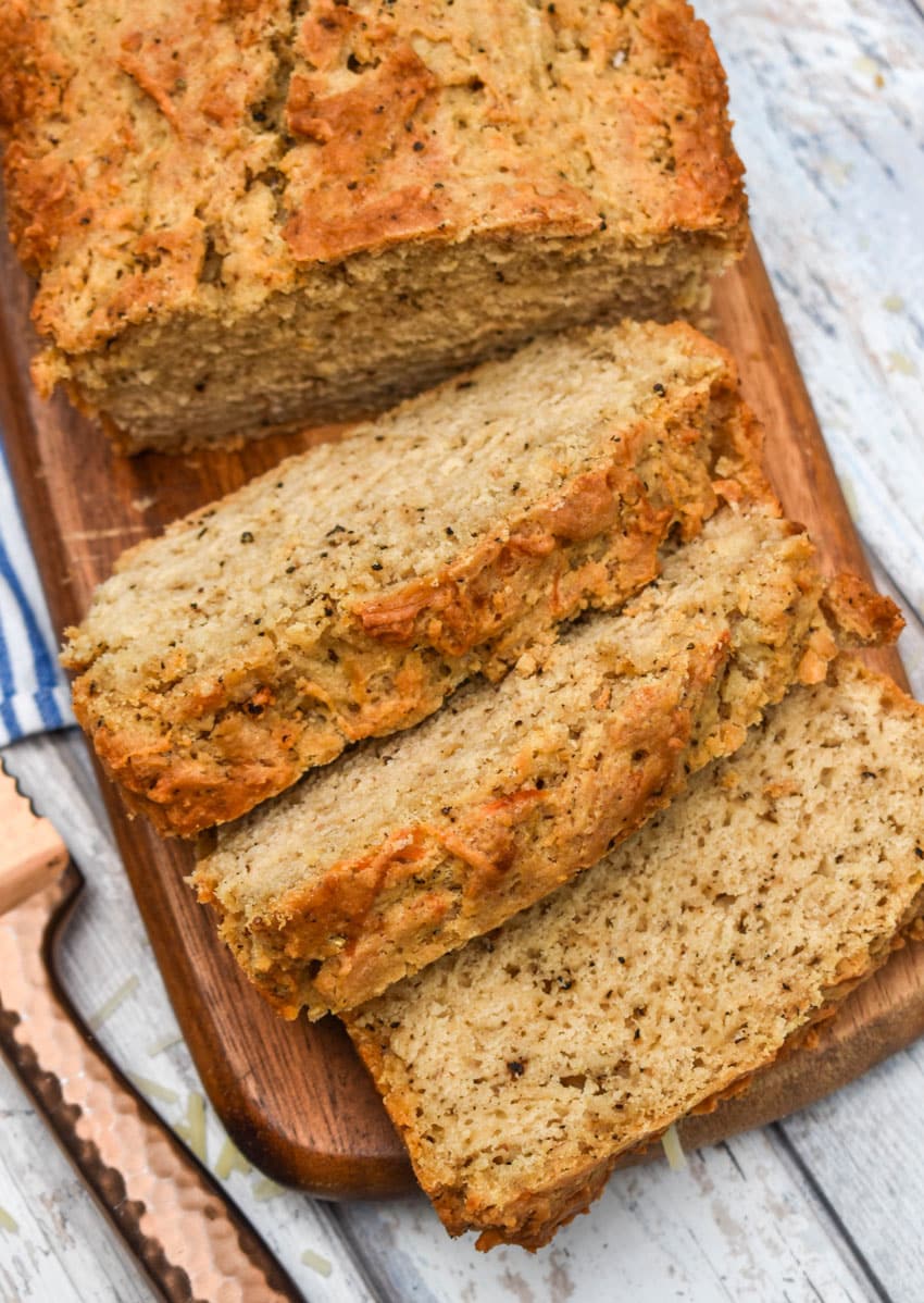slices of black pepper parmesan beer bread on a wooden cutting board