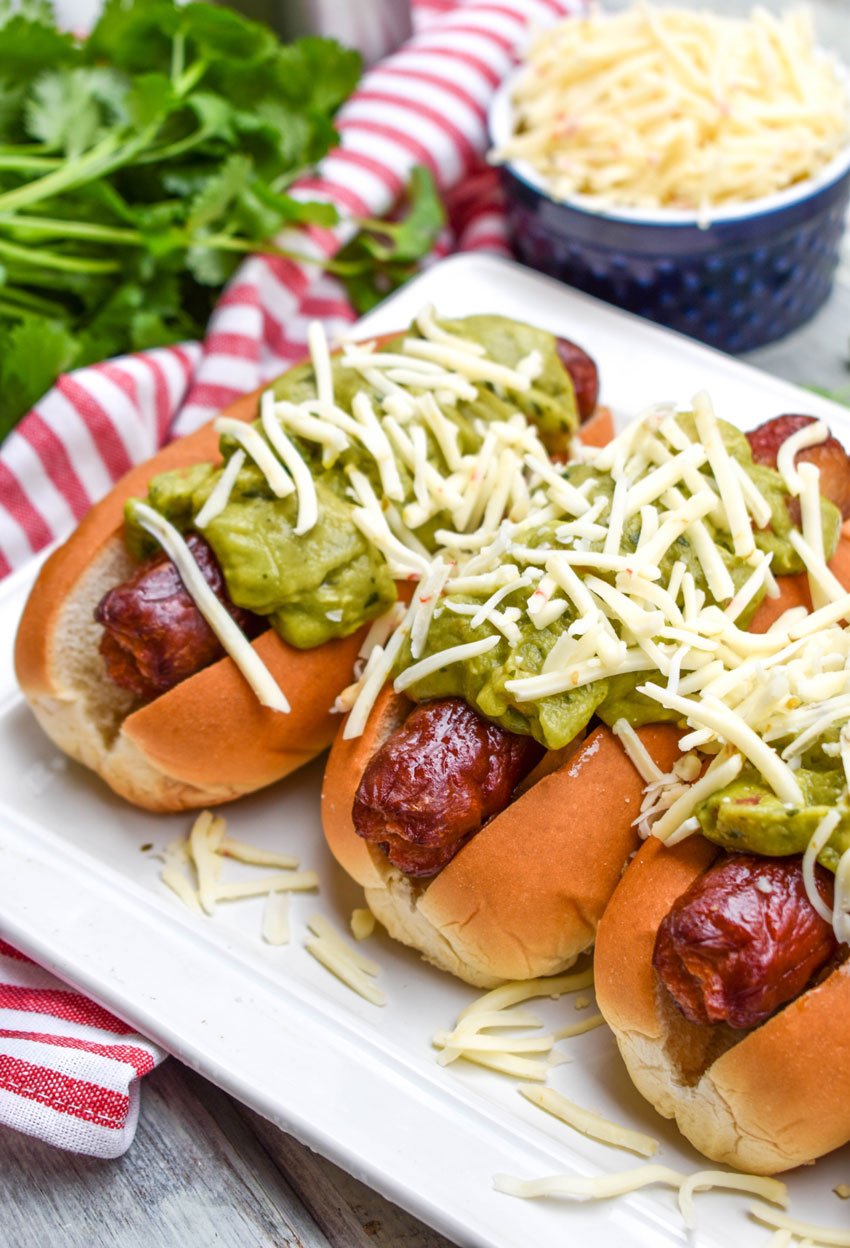 a row of california dogs arranged on a white serving platter