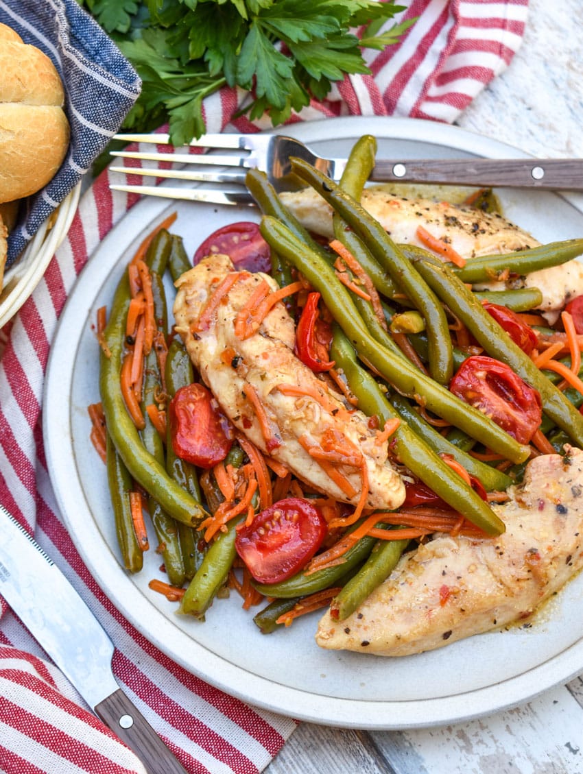 one pot balsamic chicken and veggies on a white plate with a fork resting on the side
