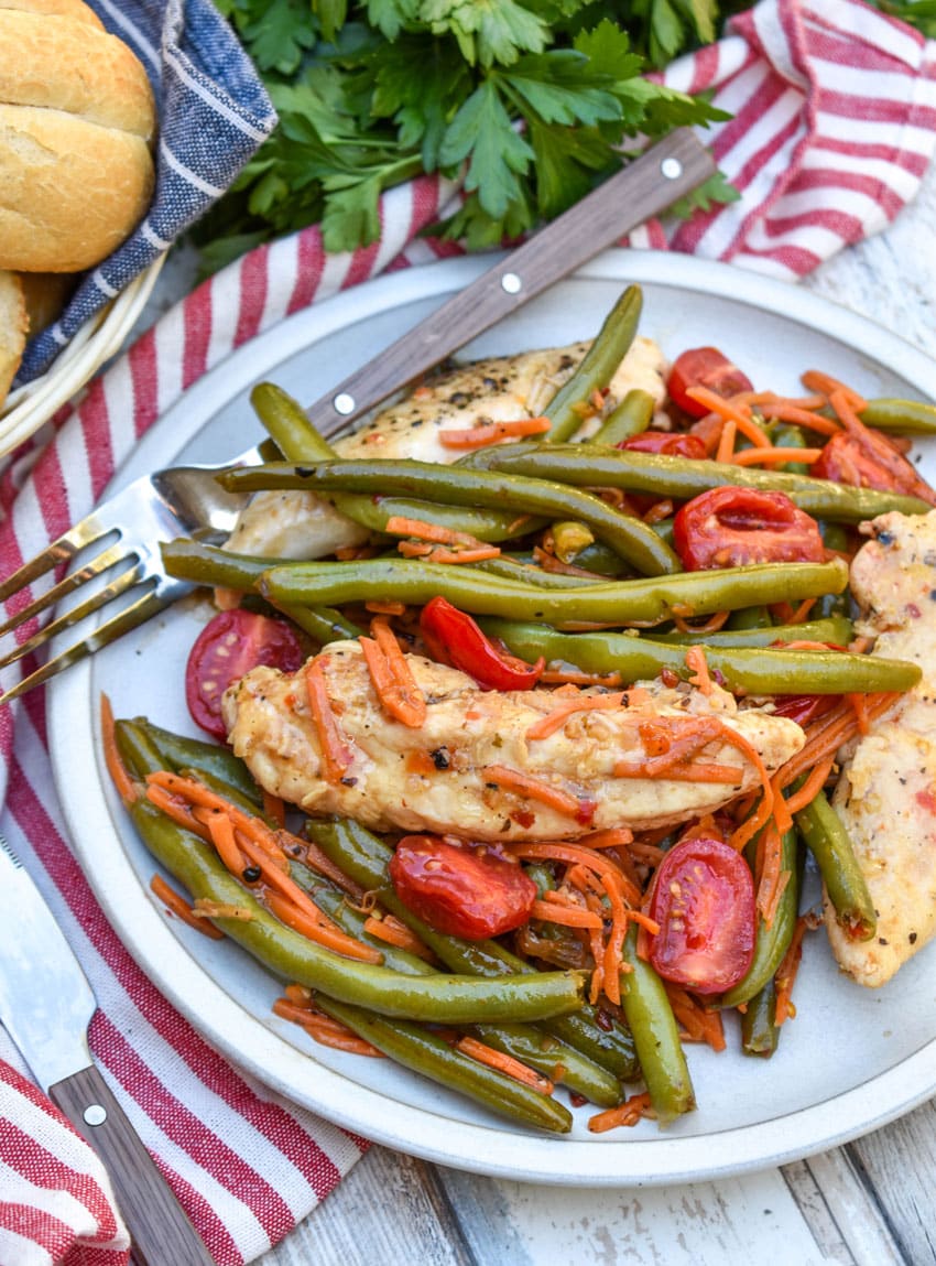 one pot balsamic chicken and veggies on a white plate with a fork resting on the side